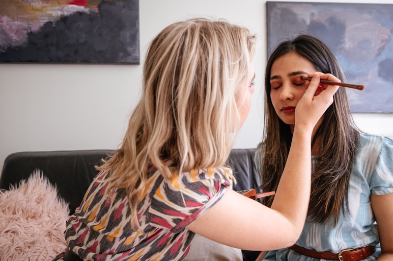 Destiny at work, brush in hand, shaping a client's eye makeup in the studio